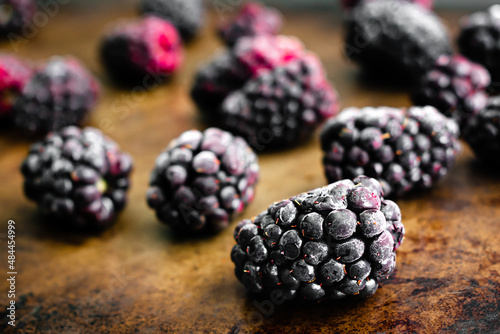 Frozen Blackberries on a Sheet Pan: Closeup view of frozen berry fruit on a metal baking pan