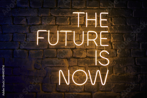 neon glowing inscription on the wall the future is now