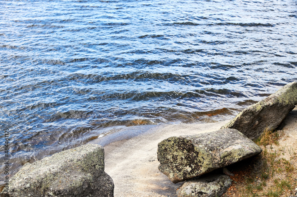 stones on the shore of a lake overgrown with forest stones on the shore of a lake overgrown with forest