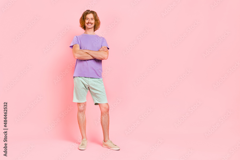 Full length body size view of attractive content cheerful funky guy folded arms isolated over pink pastel color background Full length body size view of attractive content cheerful funky guy folded arms isolated over pink pastel color background