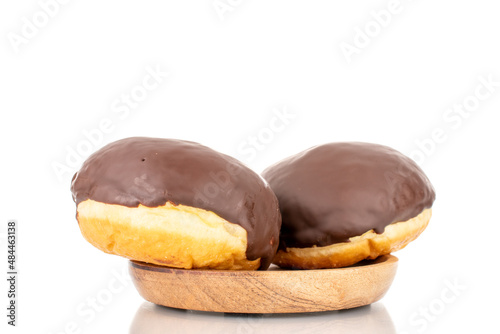 Two flavored chocolate donuts on a wooden saucer, macro, isolated on a white background.