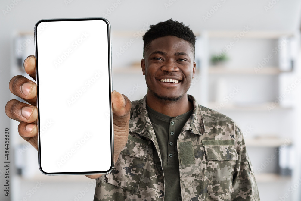 Attractive black soldier in military uniform showing his smartphone, mockup  Photos | Adobe Stock