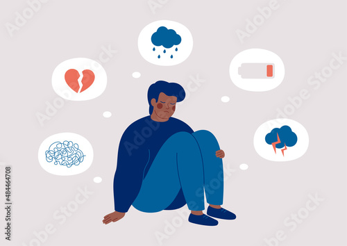 Sad  black man who suffers from mental health illness is sitting on the floor. Boy surrounded by symptoms of depression disorder: anxiety, crisis, tears, exhaustion, loss,  overworked, tired. Vector