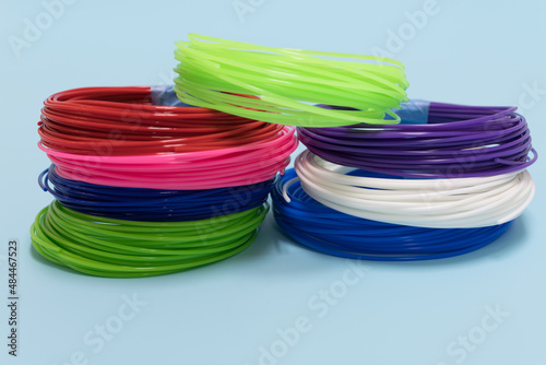 plastic filament of different colors for 3D printing on a blue background