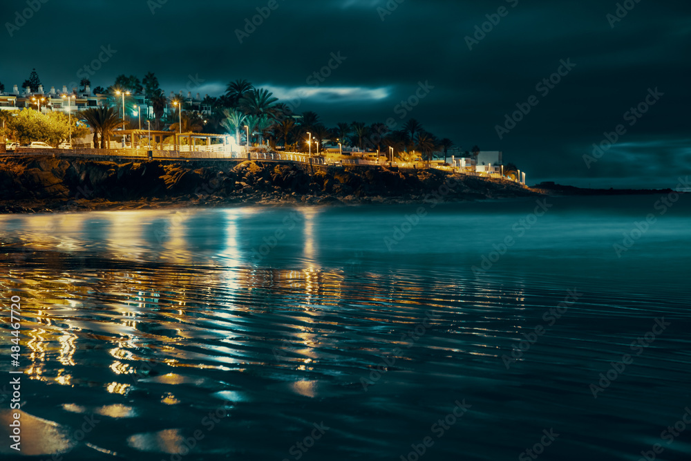 Naklejka premium cape with hotels and reflection in the sea at night