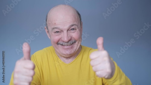 Senior man doing positive gesture with hand, thumbs up smiling and happy.