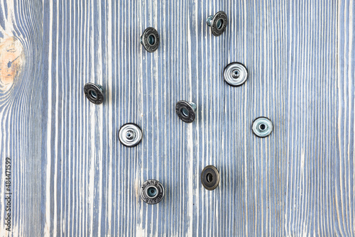 Buttons for jeans on a wooden table.