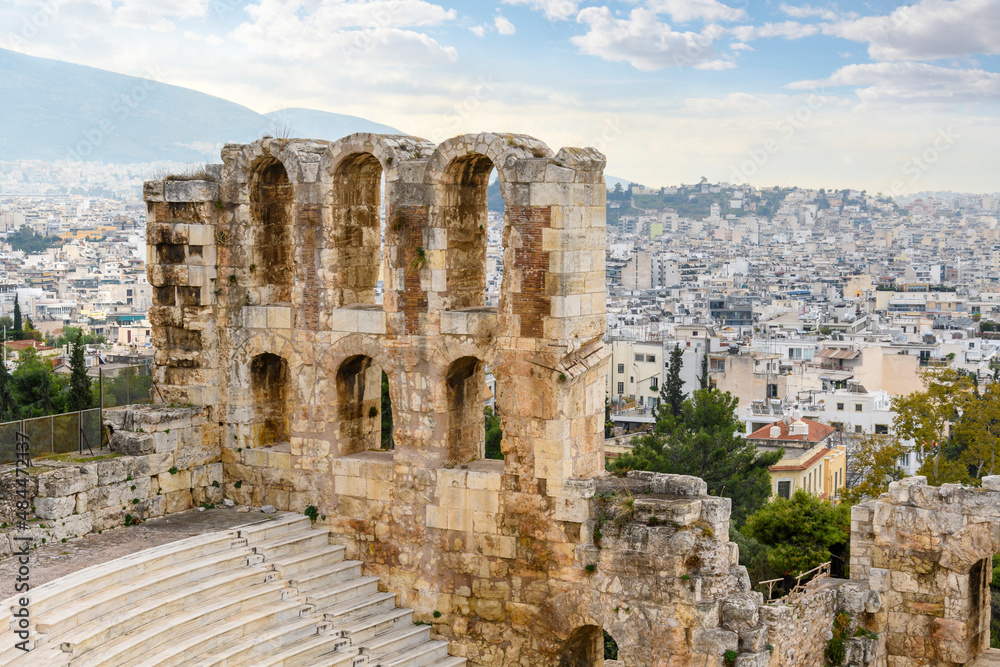 One of the walls and arches of the Odeon of Herodes Atticus, the ancient amphitheater at the south base of Acropolis Hill, with the modern city of Athens, Greece behind.