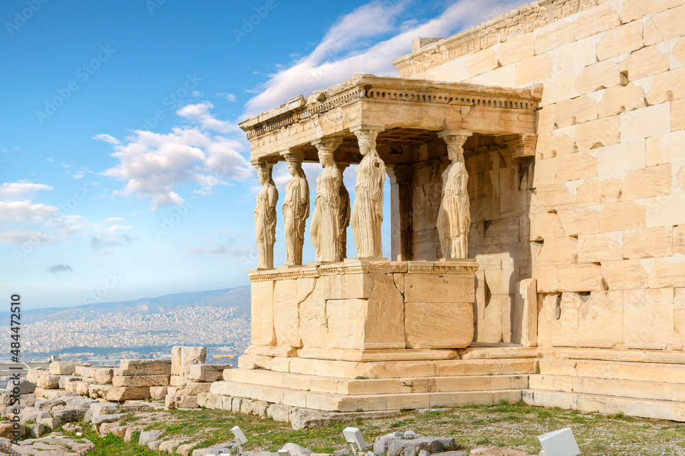 View of the Erechtheion temple at the Athens Acropolis in Athens Greece on a warm summer day with Lykavittos Hill in the background	