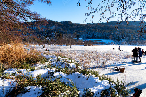 People skating on frozen Keutschacher lake in Carinthia, Austria photo