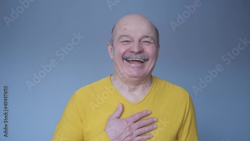 Senior hispanic man looking confident at camera smiling pointing at you.