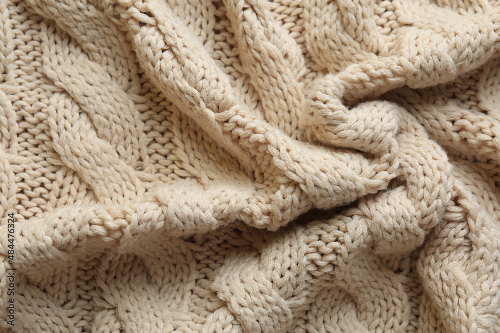 Beige knitted fabric with beautiful pattern as background, top view Beige knitted fabric with beautiful pattern as background, top view