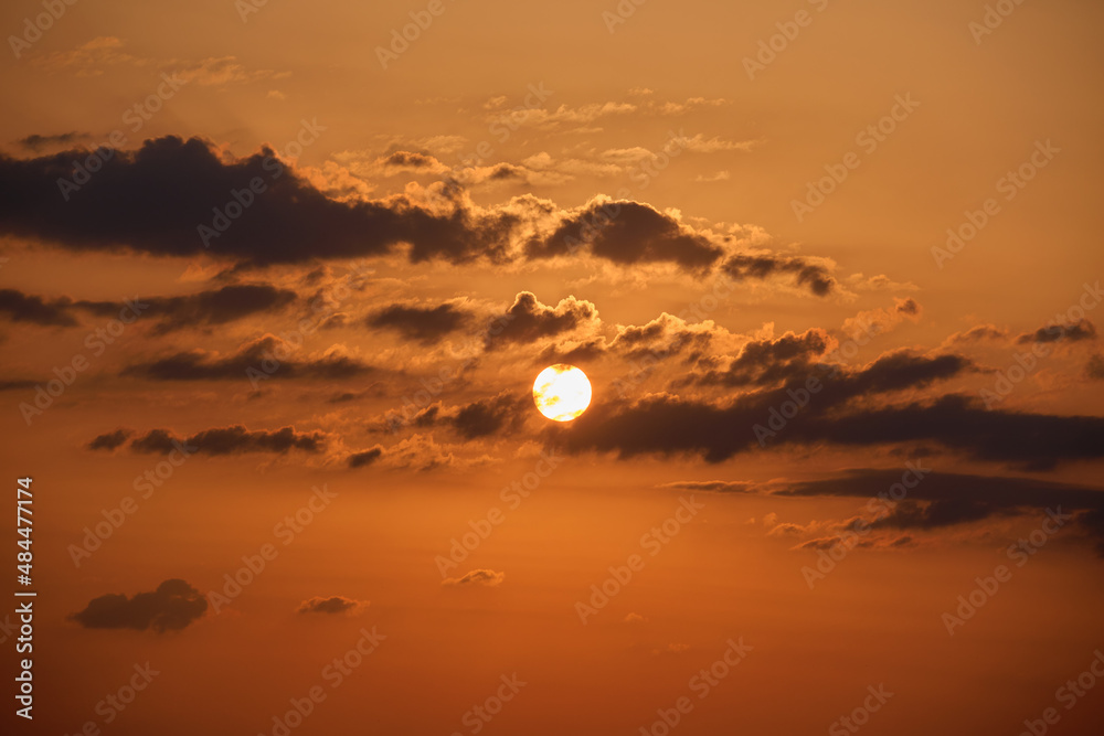 Fototapeta premium Bright colorful sunset sky with rays of setting sun and vivid dark clouds