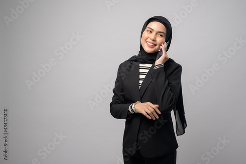 Portrait of beautiful woman with hijab using cellphone on white background