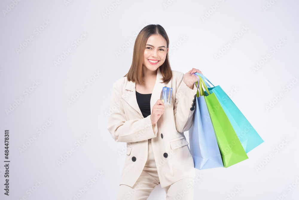Portrait of Young beautiful woman in suit holding credit card over white background in studio. Portrait of Young beautiful woman in suit holding credit card over white background in studio.