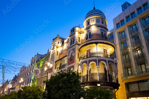 The Confitería Filella, a well known landmark building with domr and round balconies in downtown Seville, Spain, at early evening.