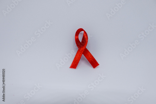 Listones de colores, cintas de campañas de lucha contra el cáncer y SIDA. Manos preparando listones rojos y verdes. Rojo campaña de concientización contra el VIH photo