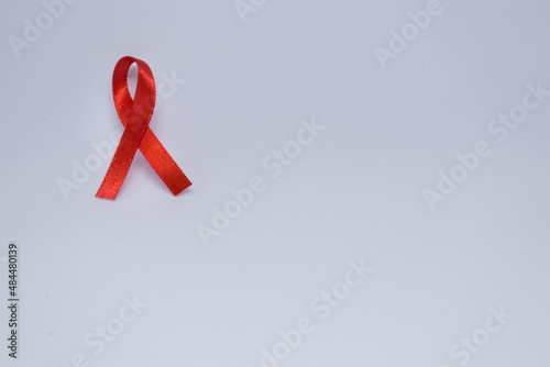 Listones de colores, cintas de campañas de lucha contra el cáncer y SIDA. Manos preparando listones rojos y verdes. Rojo campaña de concientización contra el VIH photo