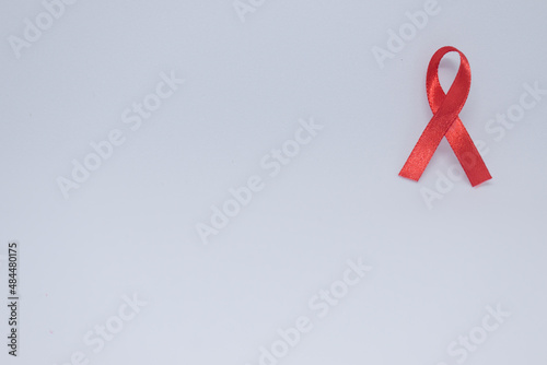 Listones de colores, cintas de campañas de lucha contra el cáncer y SIDA. Manos preparando listones rojos y verdes. Rojo campaña de concientización contra el VIH photo