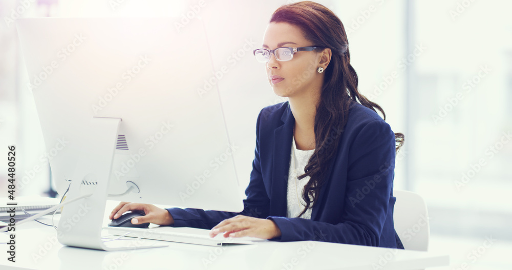Shes got a goal in mind. Cropped shot of an attractive young businesswoman working on her computer in the office. Shes got a goal in mind. Cropped shot of an attractive young businesswoman working on her computer in the office.