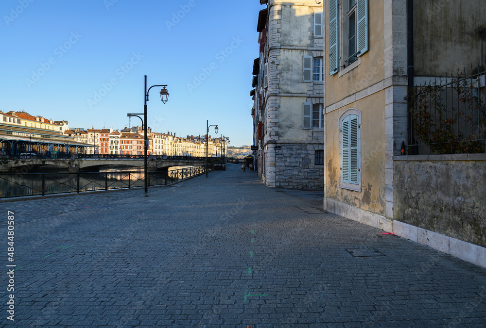 Petit Bayonne, french basque country, walk along the river Nive at its entrance, the old city, the bridge over the river and the buildings of the city in the sun, and the walk in the shade, without pe