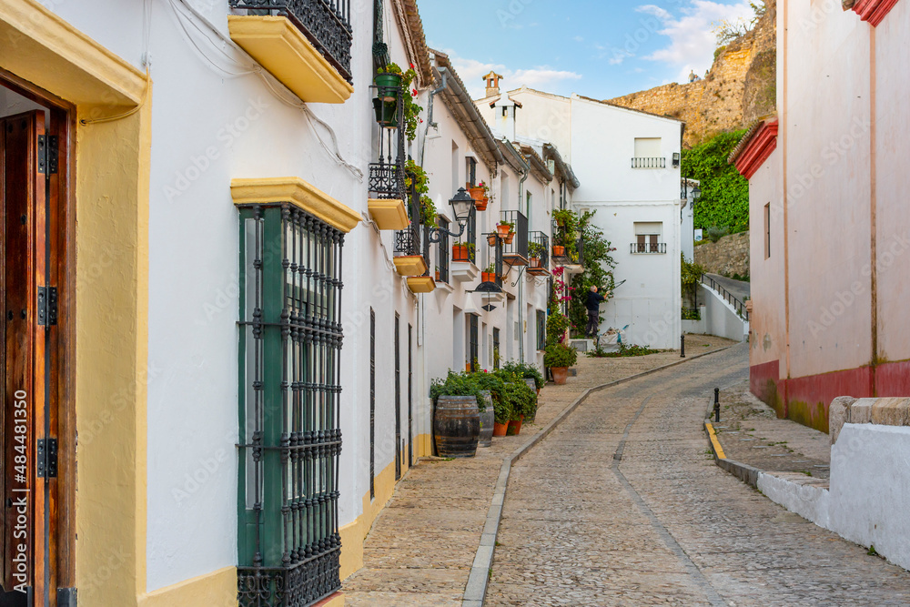 A picturesque, colorful traditional street in the White Village of Zahara de la Sierra in the Andalusian region of Southern, Spain.