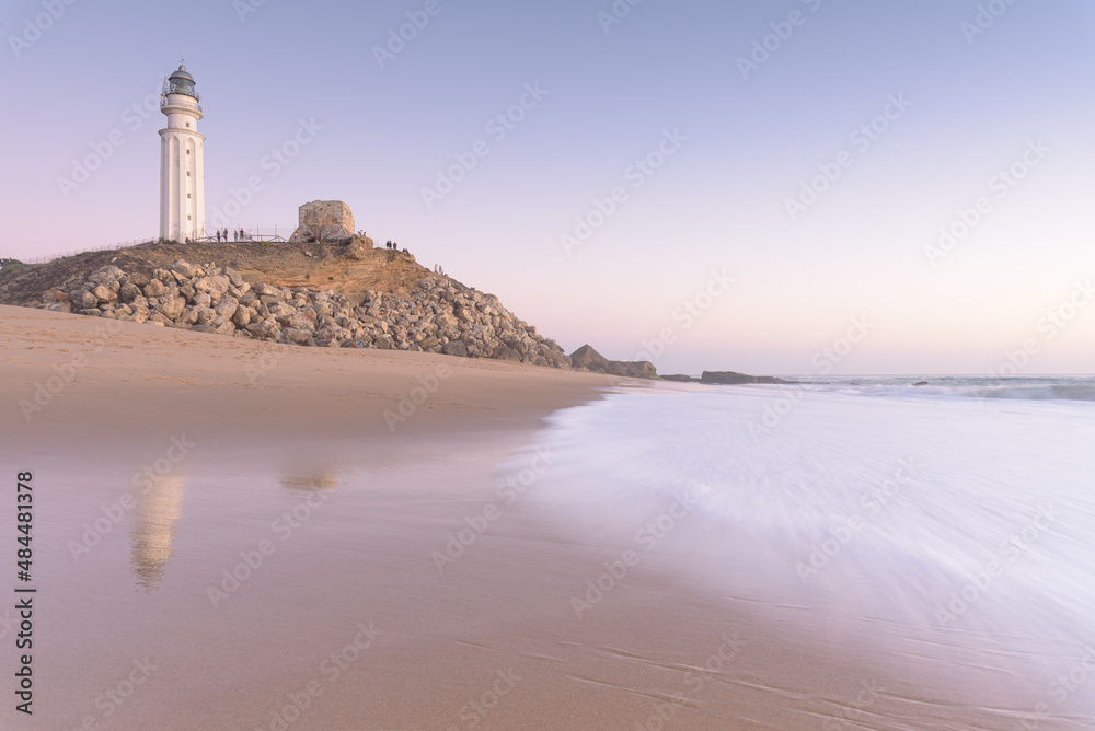 Sunset on the beach of Cape Trafalgar with the lighthouse in the background, Canos de Meca, Cadiz, Andalusia, Spain