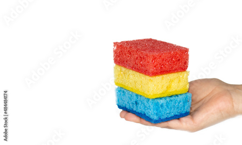 Multi Colored sponges for cleaning in a girl's palm. blue, red, yellow colors. space for text. Kitchen cleaning set sponge background.