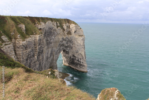 a beautiful arch in the white cliffs in the sea at the french coast in normandy in summer