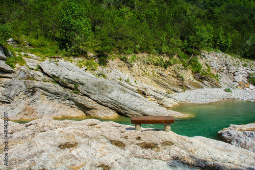 A wooden bench by the side of the Torrente Aupa river in the Moggio Udinese municipality of Udine province, Friuli-Venezia Giulia, north east Italy. July
 photo