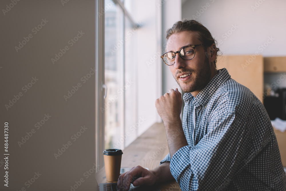 Naklejka premium Caucasian businessman work at windowsill in office