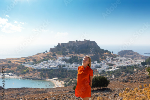 A blonde woman looks at the panorama of Lindos on the island of Rhodes, Greece photo