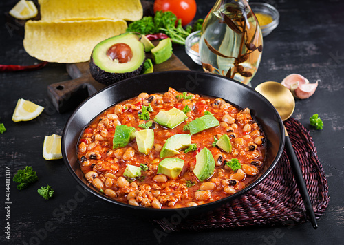 Chili con carne in bowl on dark background. Mexican cuisine.