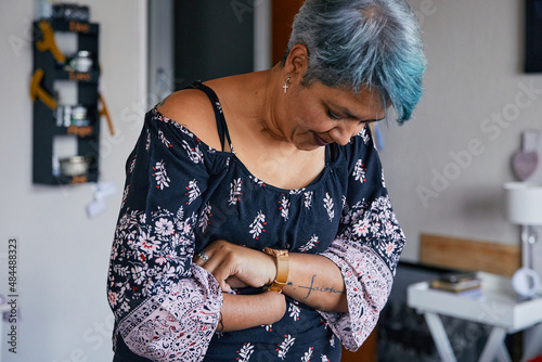Woman with one hand putting on a watch photo
