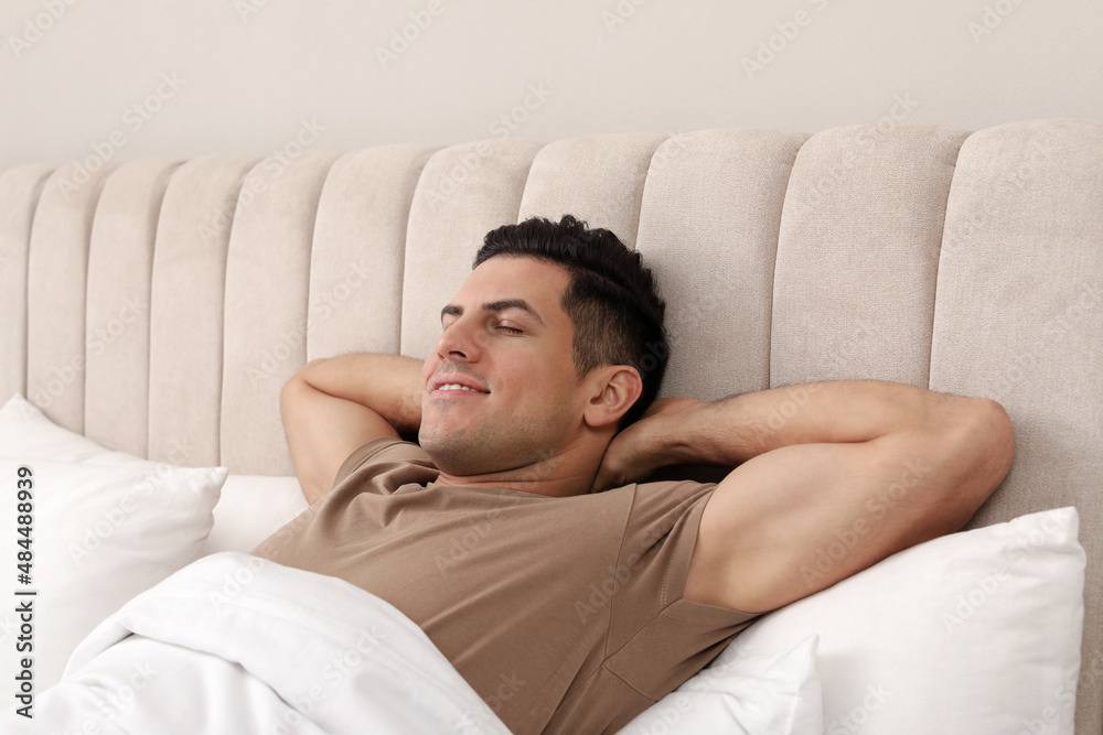 Happy man lying in bed at home Happy man lying in bed at home