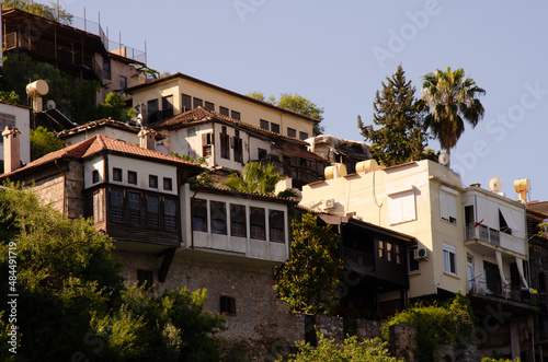 Landscapes of Turkish resort town. Old houses with palm trees are located on hillside. Holidays in Turkey with copy space.