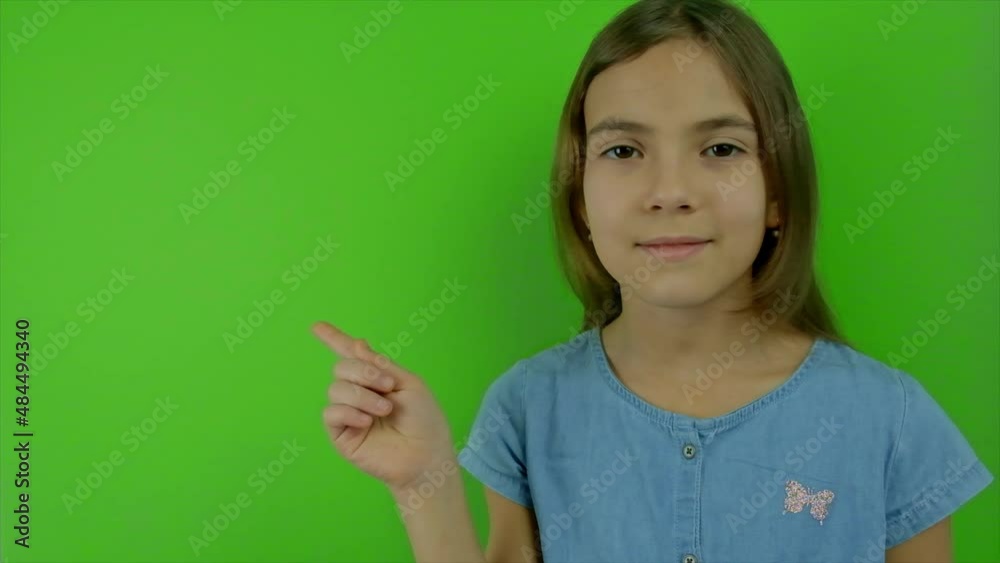 The child thinks on a green background. Selective focus. The child thinks on a green background. Selective focus.