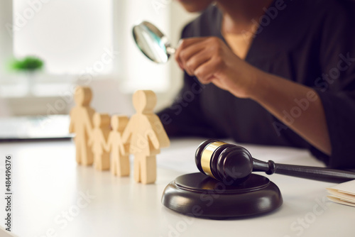 Crop close up of gavel on table of lawyer deal with family or matrimonial law. Juror with magnifier work with domestic relations cases in courthouse. Legislation and jurisdiction concept. photo