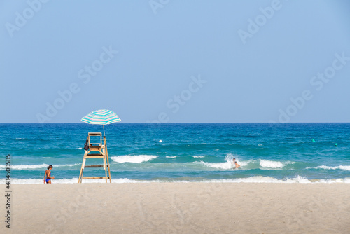 sunbathers and watchtower on the beach