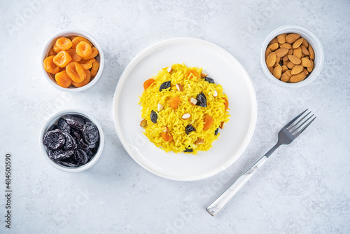 Turmeric basmati rice with dried apricots and prunes and almonds in a plate