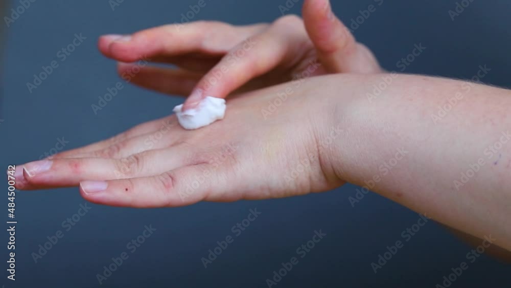 Close-up of women's hands on a gray background. A young woman is going to smear her hands with a moisturizing, nourishing cream. The concept of personal hygiene and care products.Dry, damaged skin. Close-up of women's hands on a gray background. A young woman is going to smear her hands with a moisturizing, nourishing cream. The concept of personal hygiene and care products.Dry, damaged skin.
