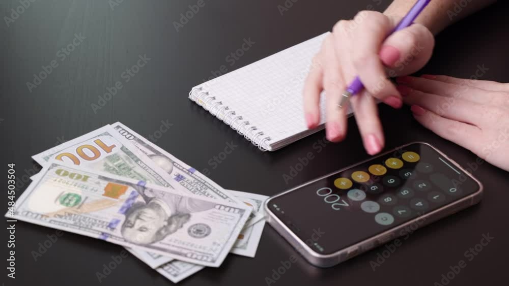 Budget planning using calculator, notepad. 100 US dollar bills are on the table Budget planning using calculator, notepad. 100 US dollar bills are on the table