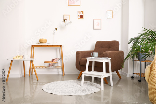 Interior of light living room with armchair and white step stool © Pixel-Shot