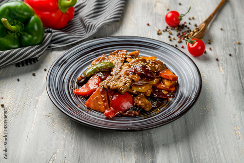 Fototapeta Naklejka Na Ścianę i Meble -  Fried beef with pepper Chinese cuisine on grey wooden table