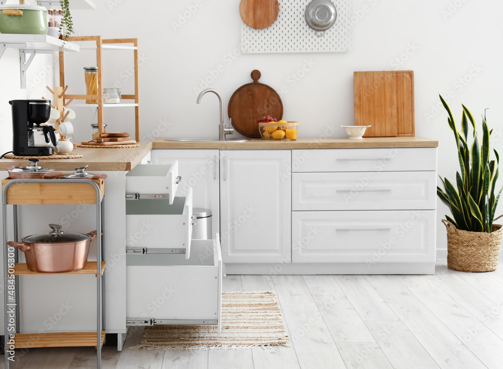 Interior of kitchen with modern counters and opened drawers
