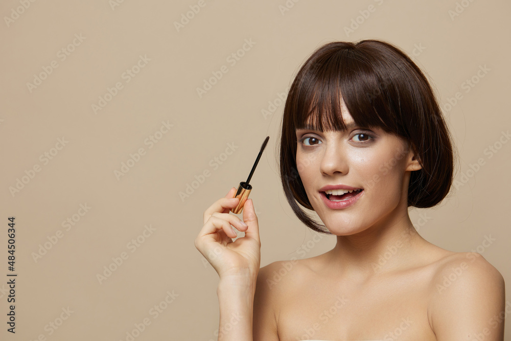 brunette paints eyelashes bare shoulders close-up Lifestyle brunette paints eyelashes bare shoulders close-up Lifestyle
