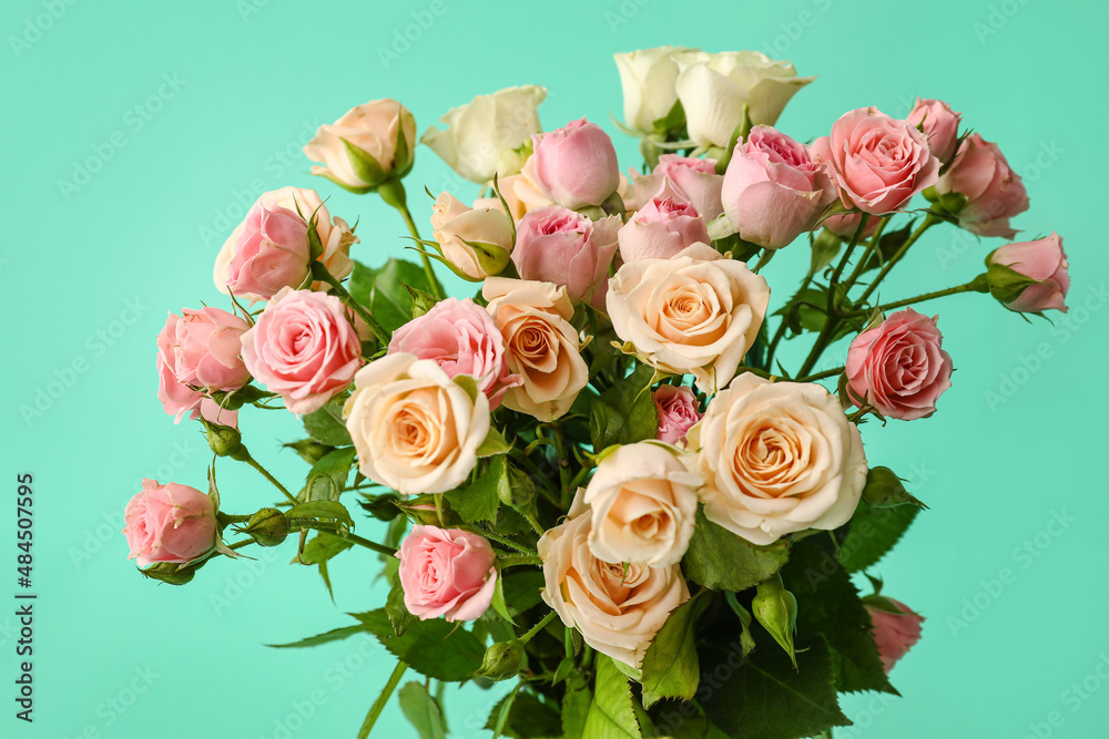 Fototapeta premium Bouquet of beautiful small roses on green background