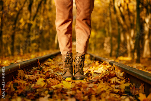 Female fashion boots over autumn railroad tack