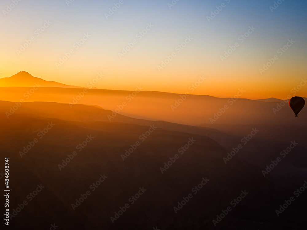 Silhouette of hot air balloon in sky at sunrise nature background above the mountains at Cappadocia.