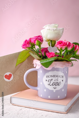 Valentines day greeting card with book, love envelope and roses in the mug